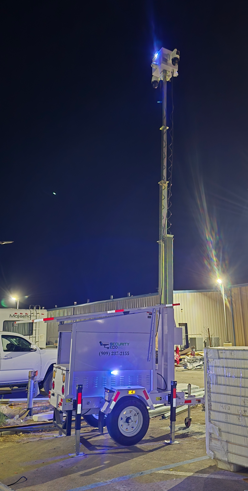 Security Eco mobile trailer deployed at night with blue warning lights and raised mast